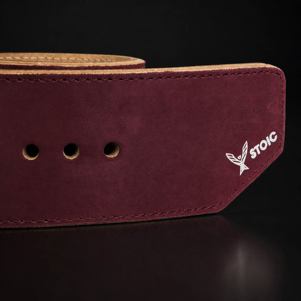 Stoic 10mm single-prong weight lifting belt in maroon, a close view of the strap, its adjustment holes and the angled tail tip.
