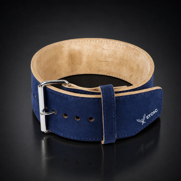 Stoic 10mm single-prong weight lifting belt in navy, the belt coiled into a ring, seen from the front with the buckle at the left and the tan suede interior visible.