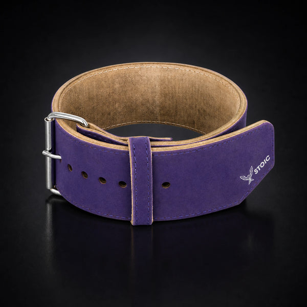 Stoic 10mm single-prong weight lifting belt in purple, the belt coiled into a ring, seen from the front with the buckle at the left and the tan suede interior visible.