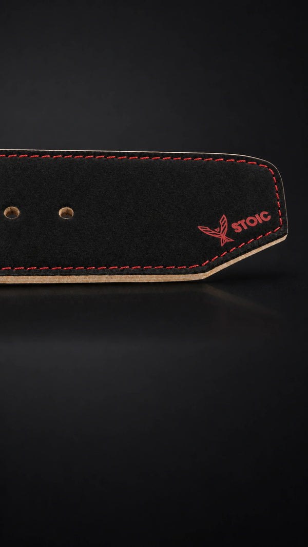 Stoic 10mm single-prong weight lifting belt in Bloodline red and black, a close view of the tail, its adjustment holes and the angled chamfered tip.