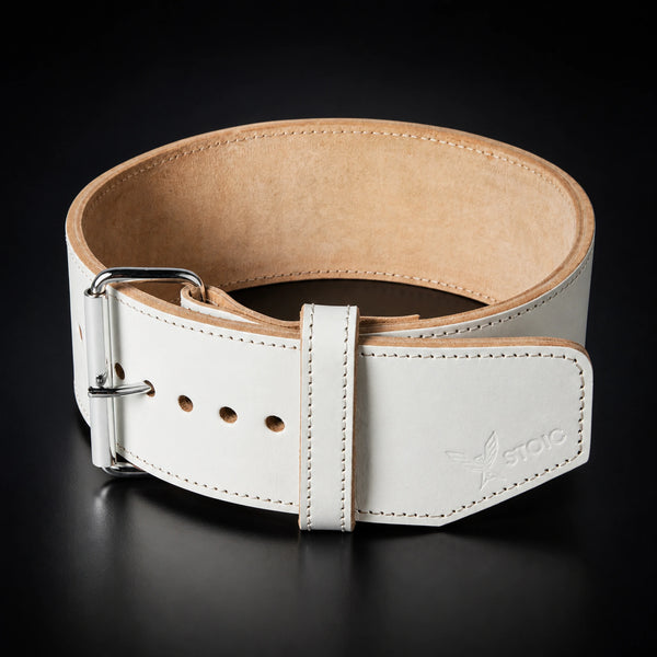 Stoic 10mm single-prong weight lifting belt in white, the belt coiled into a ring, seen from the front with the buckle at the left and the tan suede interior visible.