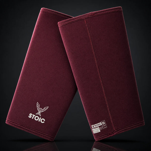 Stoic 7mm knee sleeves for weightlifting in maroon, on a dark studio background
