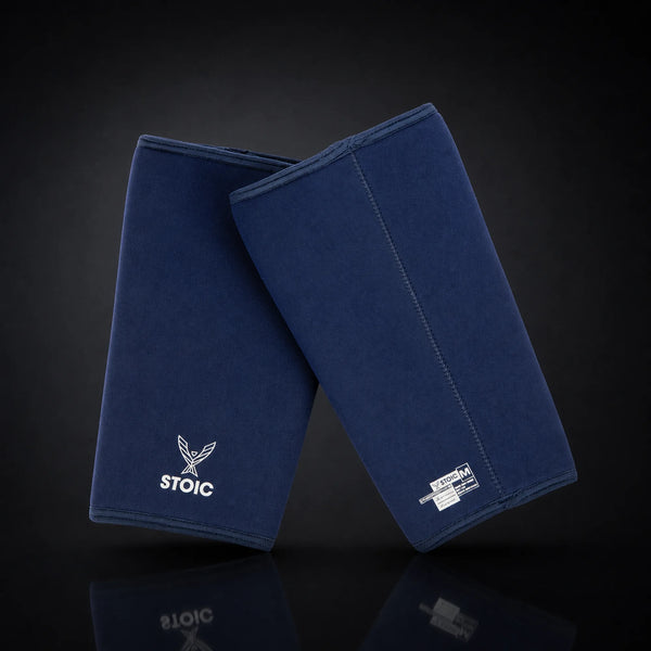 Stoic 7mm knee sleeves for weightlifting in navy, on a dark studio background