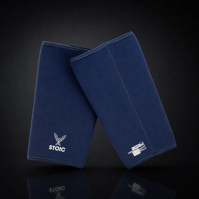 Stoic 7mm knee sleeves for weightlifting in navy, on a dark studio background