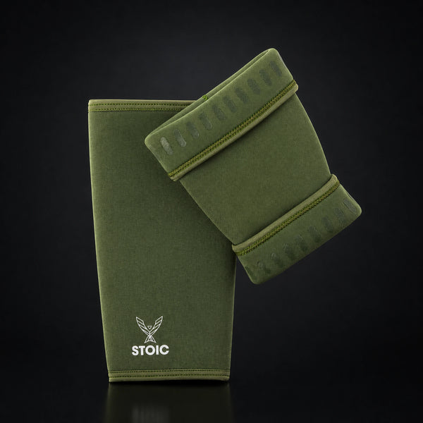 Stoic 7mm knee sleeves for weightlifting in olive drab, the pair arranged with one sleeve showing the phoenix logo on its front and the other turned to reveal the silicone grip dashes inside the cuffs.