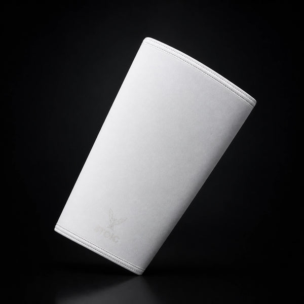 Stoic 7mm knee sleeves for weightlifting in white, a single sleeve leaning at an angle, front face with the phoenix logo.
