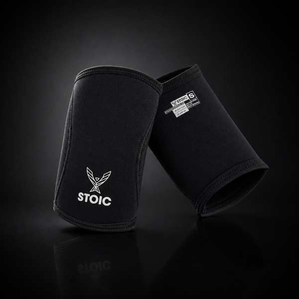Stoic 7mm neoprene elbow sleeves in black, front view, on a dark studio background