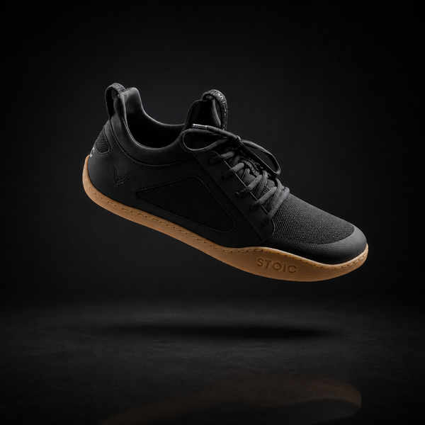 Stoic Barefoot Trainer zero-drop lifting shoe in black, angled view, on a dark studio background