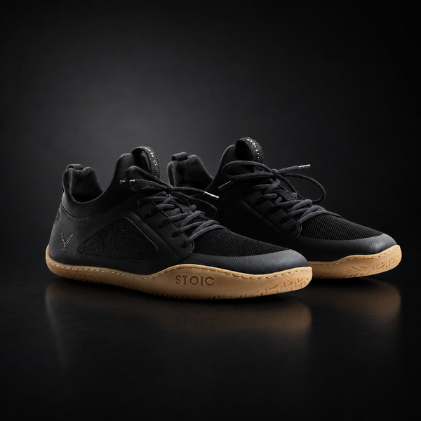 Stoic Barefoot Trainer zero-drop minimalist lifting shoe in black, side view, on a dark studio background