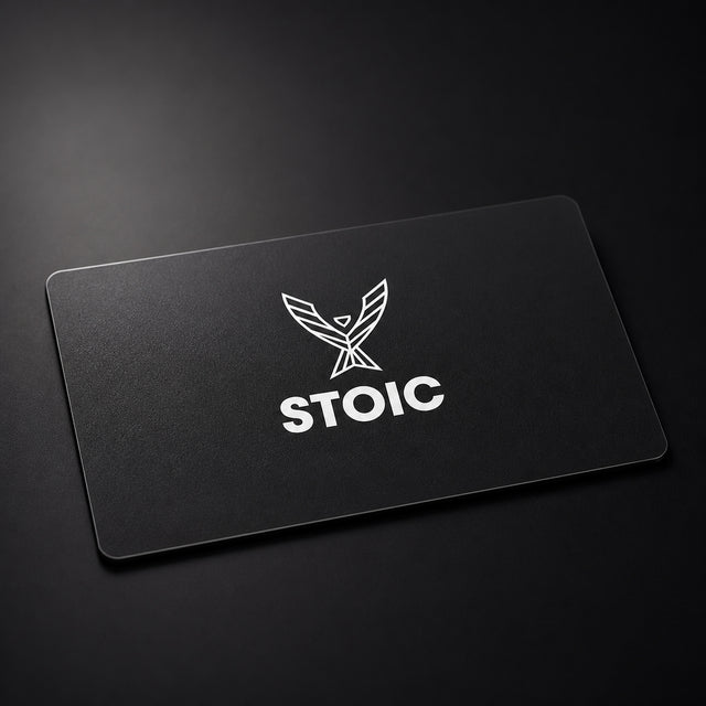 Stoic Performance gift card, a matte black card with the white Stoic phoenix logo, on a dark low-key studio background