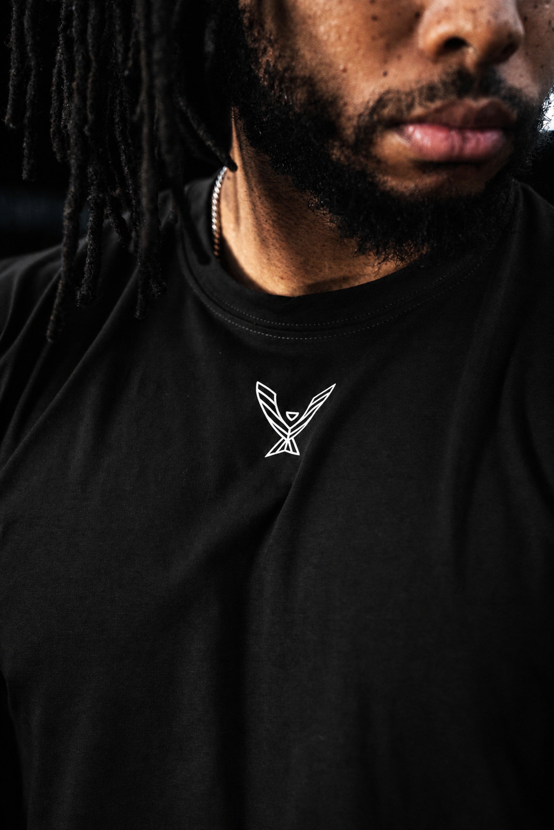 Close-up of the white Phoenix logo on the black Stoic Competition T-Shirt
