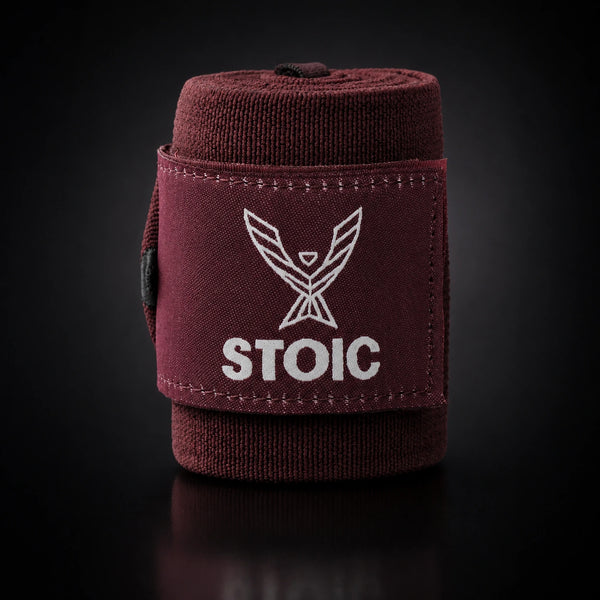 Stoic wrist wraps for weightlifting in maroon, a single rolled wrap standing, logo patch facing the camera.
