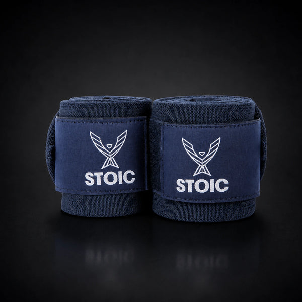 Stoic wrist wraps for weightlifting in navy, two rolled wraps standing together, both logo patches facing the camera.