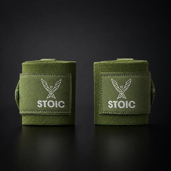 Stoic wrist wraps for weightlifting in olive drab, two rolled wraps standing apart, both logo patches facing the camera.