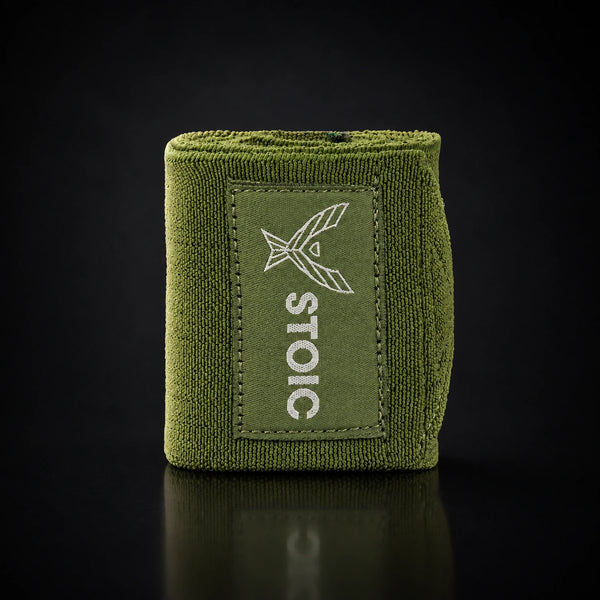 Stoic wrist wraps for weightlifting in olive drab, a single rolled wrap standing, logo patch facing the camera.