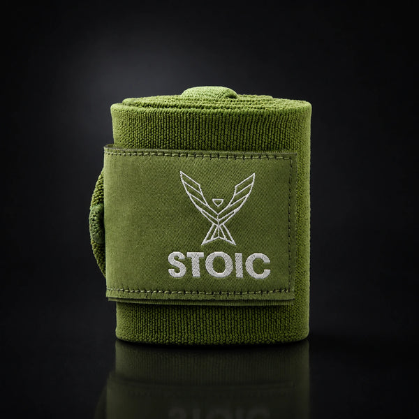 Stoic wrist wraps for weightlifting in olive drab, a single rolled wrap standing, with the elastic tail curling around behind it.