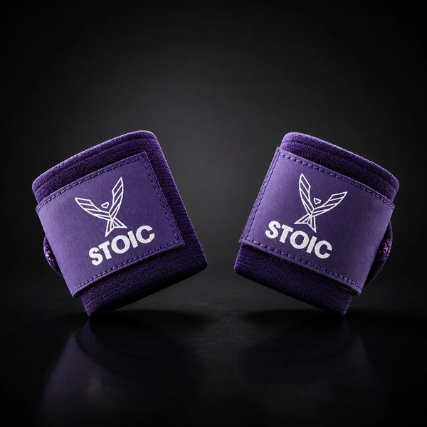 Stoic wrist wraps for weightlifting in purple, two rolled wraps tilted toward each other, logo patches facing the camera.