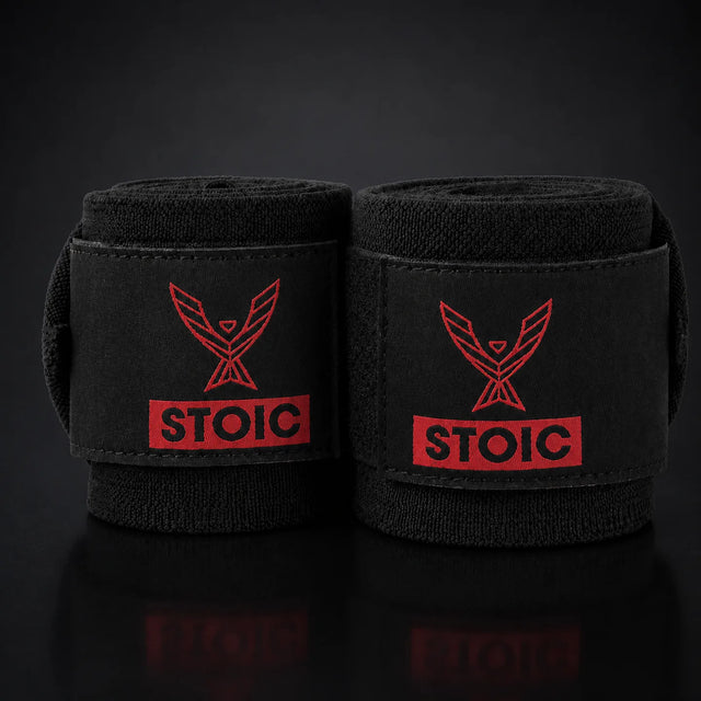 Stoic wrist wraps for weightlifting in red and black, on a dark studio background