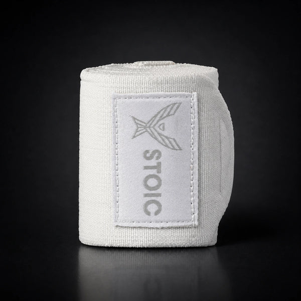 Stoic wrist wraps for weightlifting in white, a single rolled wrap standing, logo patch facing the camera.